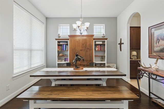 2114 Holly Manor Ct, Katy, TX 77493 - dining room with a chandelier, arched walkways, dark wood-style flooring, and baseboards