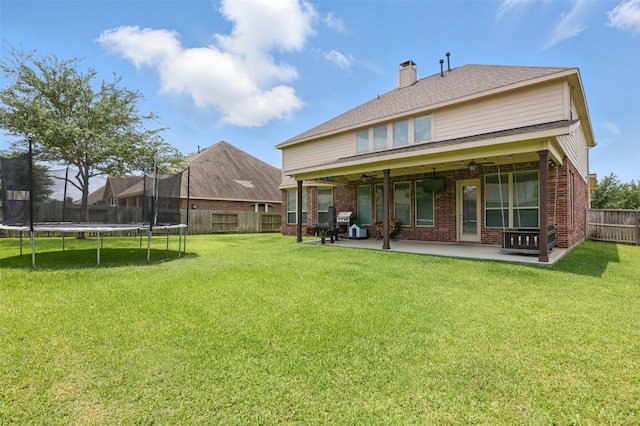 2114 Holly Manor Ct, Katy, TX 77493 - rear view of property featuring a trampoline, a ceiling fan, brick siding, a patio, and a chimney