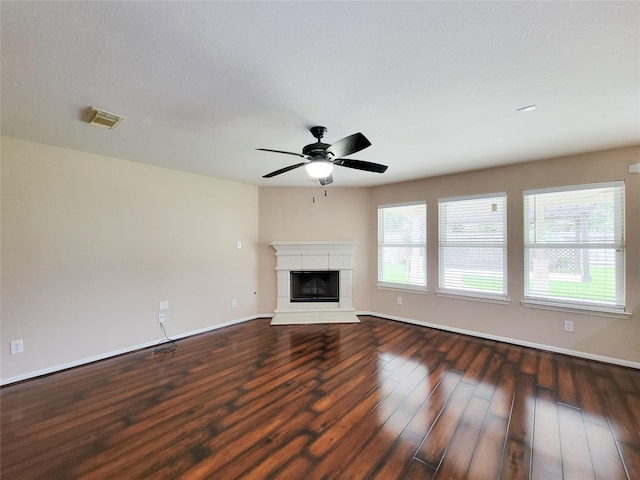 21123 Amber Crossing Dr, Richmond, TX 77406 - unfurnished living room featuring dark wood finished floors, baseboards, ceiling fan, and a tiled fireplace