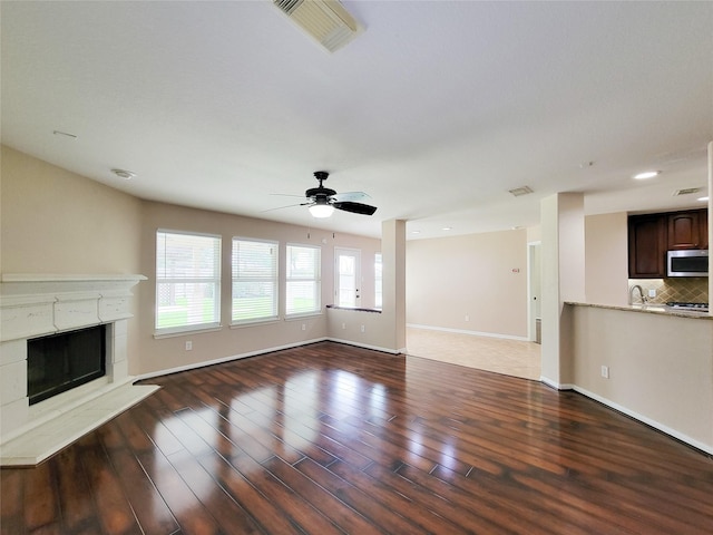 21123 Amber Crossing Dr, Richmond, TX 77406 - unfurnished living room featuring a ceiling fan, wood finished floors, a premium fireplace, and baseboards