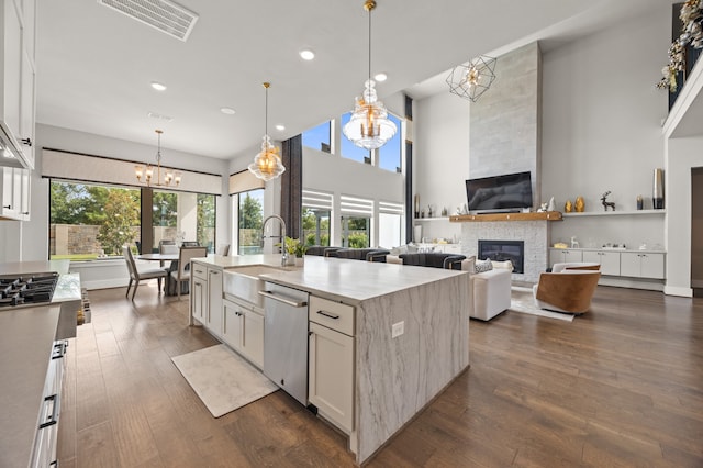 27927 Indigo Ridge Dr, Fulshear, TX 77441 - kitchen with a chandelier, stainless steel dishwasher, a stone fireplace, a sink, and recessed lighting