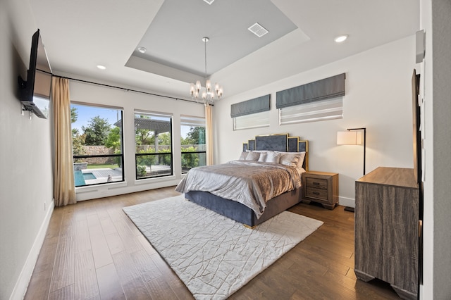 27927 Indigo Ridge Dr, Fulshear, TX 77441 - bedroom featuring a tray ceiling, a chandelier, dark wood-style floors, baseboards, and recessed lighting