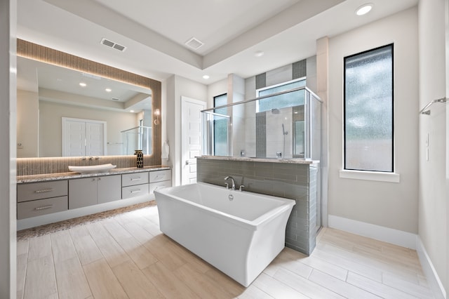 27927 Indigo Ridge Dr, Fulshear, TX 77441 - bathroom with vanity, a tray ceiling, a freestanding bath, a shower stall, and recessed lighting