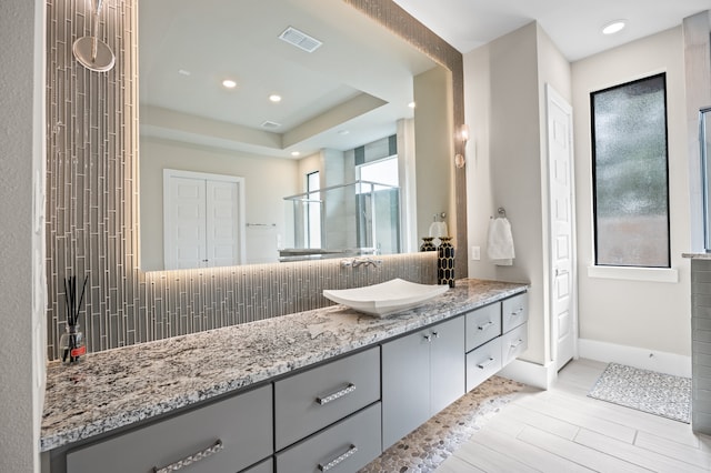 27927 Indigo Ridge Dr, Fulshear, TX 77441 - bathroom featuring vanity, backsplash, recessed lighting, wood finished floors, and a shower