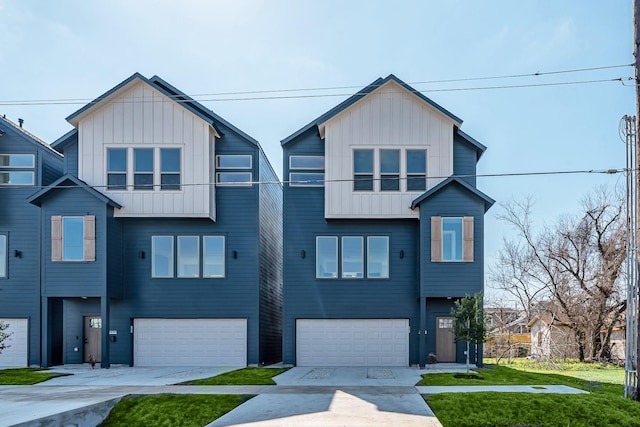 2320 Mills St, Houston, TX 77026 - view of front of house with an attached garage, board and batten siding, driveway, and a front lawn