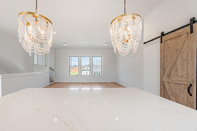 2320 Mills St, Houston, TX 77026 - unfurnished dining area with a chandelier, a barn door, stairway, light wood-style floors, and baseboards