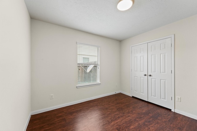 2611 Verano Dr, Richmond, TX 77406 - unfurnished bedroom with dark wood-type flooring, baseboards, and a closet