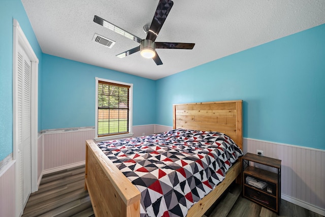 22307 Saddlewood Dr, Katy, TX 77449 - bedroom with a wainscoted wall, wood finished floors, a textured ceiling, a ceiling fan, and wooden walls