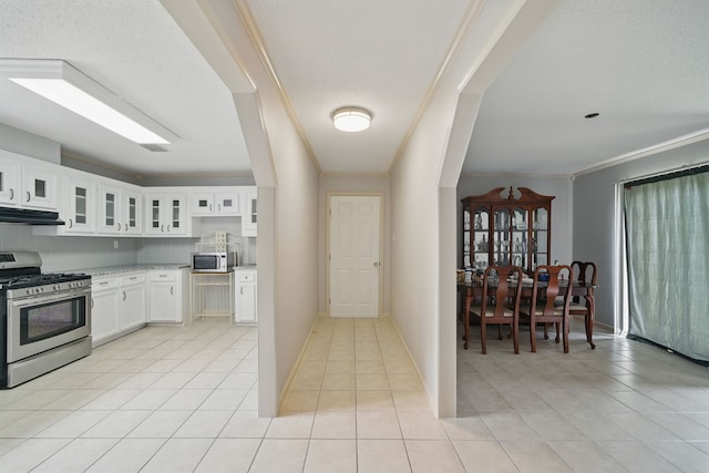 22307 Saddlewood Dr, Katy, TX 77449 - kitchen with stainless steel appliances, light tile patterned floors, extractor fan, crown molding, and glass insert cabinets