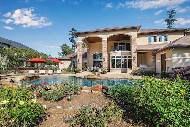 27521 Velvet Sky Way, Spring, TX 77386 - back of house featuring stucco siding, a balcony, a pool with connected hot tub, and a patio