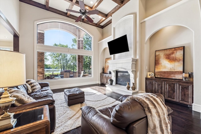 27521 Velvet Sky Way, Spring, TX 77386 - living area with a towering ceiling, coffered ceiling, a glass covered fireplace, dark wood-style flooring, and beamed ceiling