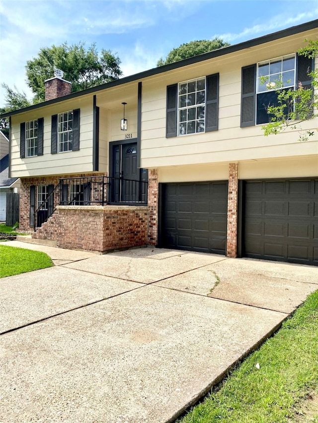 3211 Park Garden Dr, Houston, TX 77339 - raised ranch with brick siding, a garage, a chimney, and driveway