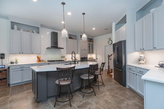 7 Fort Graham Ct, Missouri City, TX 77459 - kitchen featuring appliances with stainless steel finishes, a sink, wall chimney range hood, an island with sink, and glass insert cabinets