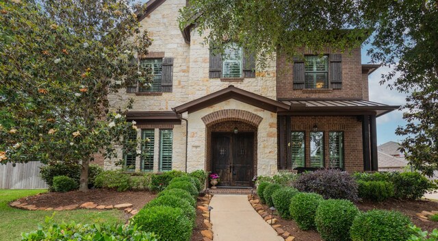 7 Fort Graham Ct, Missouri City, TX 77459 - view of front of property with a standing seam roof, stone siding, and brick siding