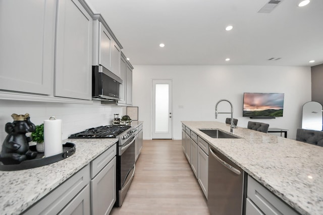 4214 Balboa Dr, Iowa Colony, TX 77583 - kitchen with stainless steel appliances, a sink, gray cabinetry, tasteful backsplash, and recessed lighting