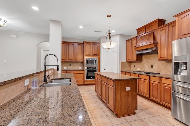 7515 Langley Rd, Spring, TX 77389 - kitchen featuring appliances with stainless steel finishes, custom range hood, dark stone counters, decorative backsplash, and arched walkways