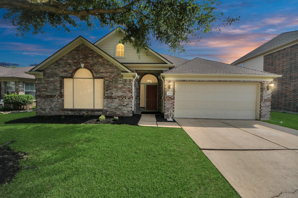 19314 Dawntreader Dr, Cypress, TX 77429 - view of front of house with a garage, a yard, concrete driveway, and brick siding