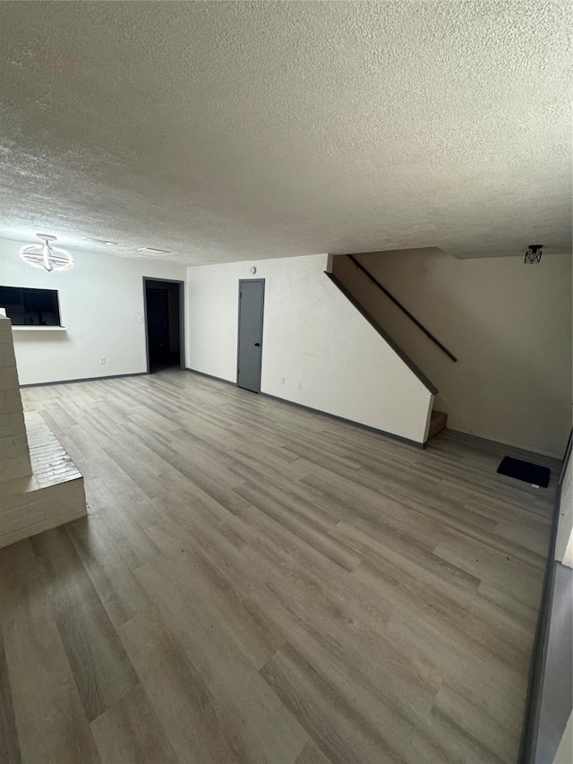 355 Audrey Ln Unit 355, Houston, TX 77015 - unfurnished living room with a textured ceiling, wood finished floors, stairway, baseboards, and a chandelier