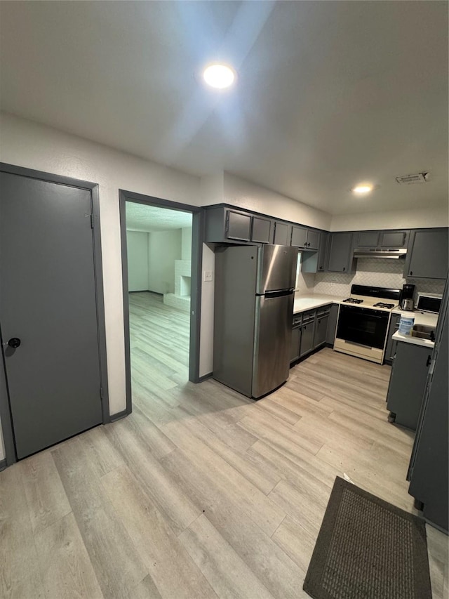 355 Audrey Ln Unit 355, Houston, TX 77015 - kitchen with range with gas stovetop, freestanding refrigerator, light wood-type flooring, light countertops, and gray cabinets
