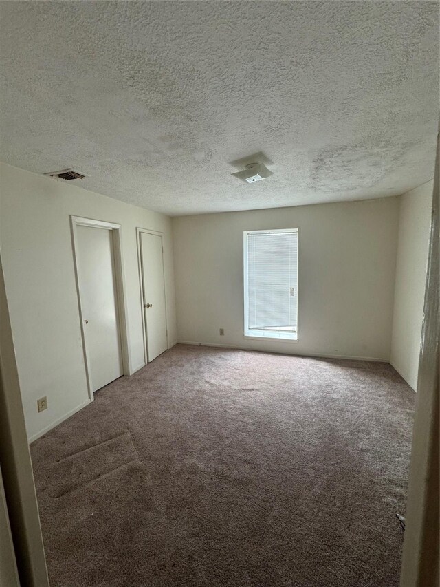 355 Audrey Ln Unit 355, Houston, TX 77015 - unfurnished bedroom with carpet, two closets, and a textured ceiling