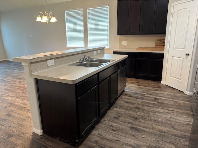 2309 Shady Tree Ln, Conroe, TX 77301 - kitchen with a sink, dark wood-style floors, light countertops, a kitchen island with sink, and dark cabinetry