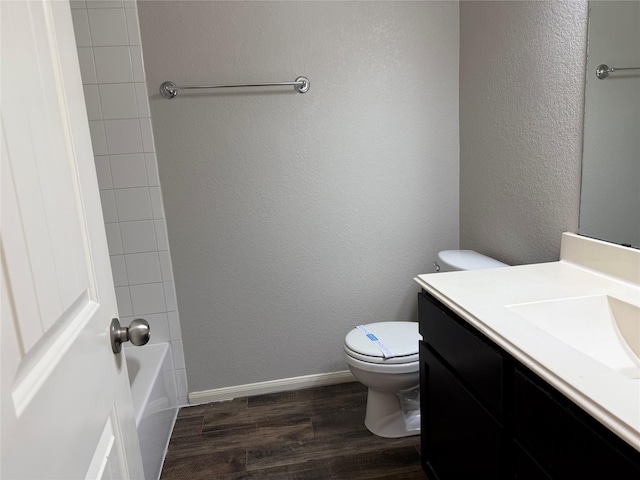 2309 Shady Tree Ln, Conroe, TX 77301 - full bathroom featuring wood finished floors, vanity, toilet, and a textured wall
