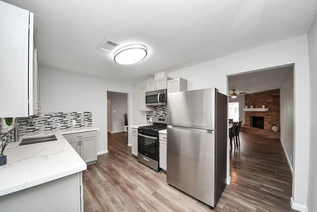 3111 Tanglebriar Dr, Pasadena, TX 77503 - kitchen with appliances with stainless steel finishes, ceiling fan, tasteful backsplash, and light wood finished floors