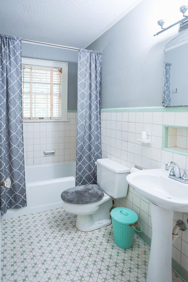 1514 Laurel St, La Marque, TX 77568 - full bath featuring tile walls, shower / tub combo with curtain, toilet, wainscoting, and a textured ceiling