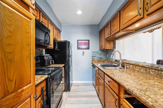 3015 Walnut Bend Ln Unit 37, Houston, TX 77042 - kitchen with black appliances, a sink, light wood-type flooring, and brown cabinets