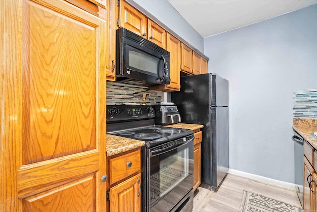 3015 Walnut Bend Ln Unit 37, Houston, TX 77042 - kitchen featuring black appliances, decorative backsplash, light wood-style flooring, baseboards, and brown cabinets