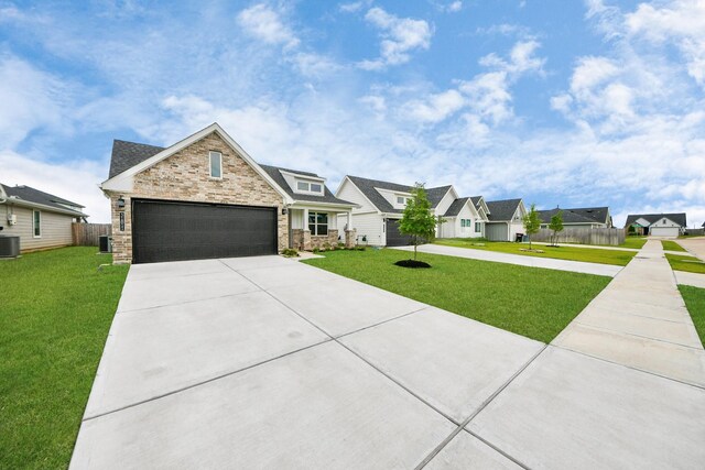 31811 Whittis Hill Way, Fulshear, TX 77441 - view of front of house featuring driveway, cooling unit, stone siding, an attached garage, and a residential view