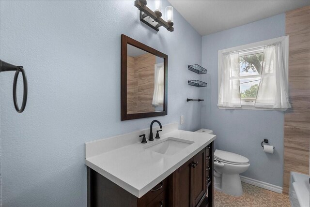 12153 24th St, Santa Fe, TX 77510 - bathroom with vanity, a tub, toilet, and baseboards