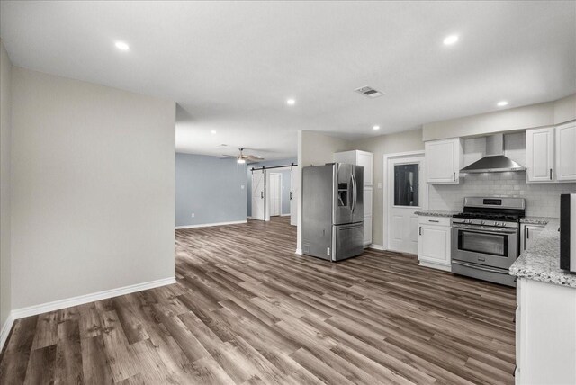 12153 24th St, Santa Fe, TX 77510 - kitchen with wall chimney range hood, stainless steel appliances, baseboards, white cabinetry, and recessed lighting