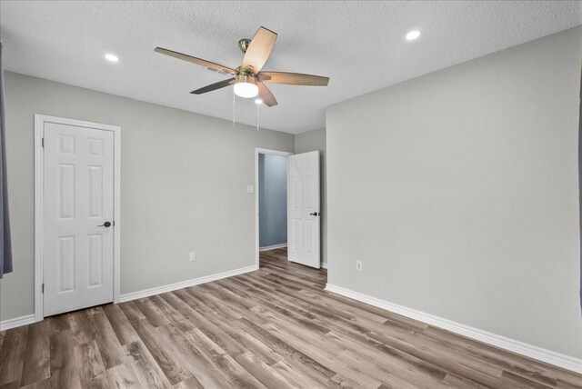 12153 24th St, Santa Fe, TX 77510 - unfurnished bedroom with wood finished floors, baseboards, a textured ceiling, a ceiling fan, and recessed lighting