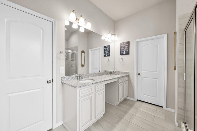 9175 White Tail Dr, Conroe, TX 77303 - bathroom with double vanity, a shower stall, and baseboards