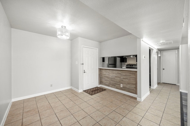 206 Plaza Verde Dr Unit D35, Houston, TX 77038 - kitchen featuring freestanding refrigerator, light tile patterned floors, baseboards, light countertops, and a textured ceiling