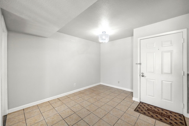 206 Plaza Verde Dr Unit D35, Houston, TX 77038 - empty room with light tile patterned floors, a textured ceiling, and baseboards