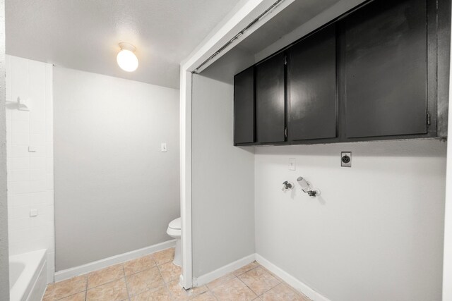 206 Plaza Verde Dr Unit D35, Houston, TX 77038 - laundry area with cabinet space, hookup for an electric dryer, baseboards, and light tile patterned floors