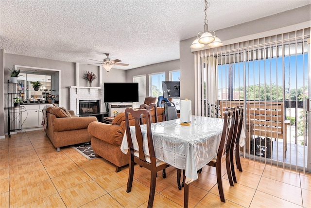 1500 Bay Area Blvd Unit 424, Houston, TX 77058 - dining room with light tile patterned flooring, a ceiling fan, a textured ceiling, and a fireplace