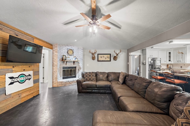 424 Hankamer Loop, Hankamer, TX 77560 - living room with ceiling fan, finished concrete floors, a brick fireplace, lofted ceiling, and a textured ceiling