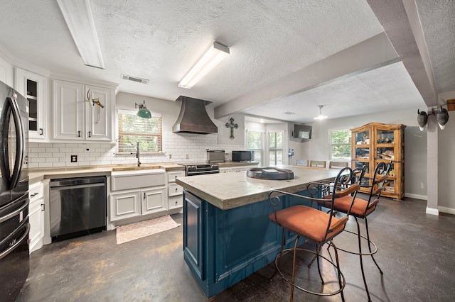 424 Hankamer Loop, Hankamer, TX 77560 - kitchen featuring custom exhaust hood, appliances with stainless steel finishes, a sink, concrete flooring, and a textured ceiling
