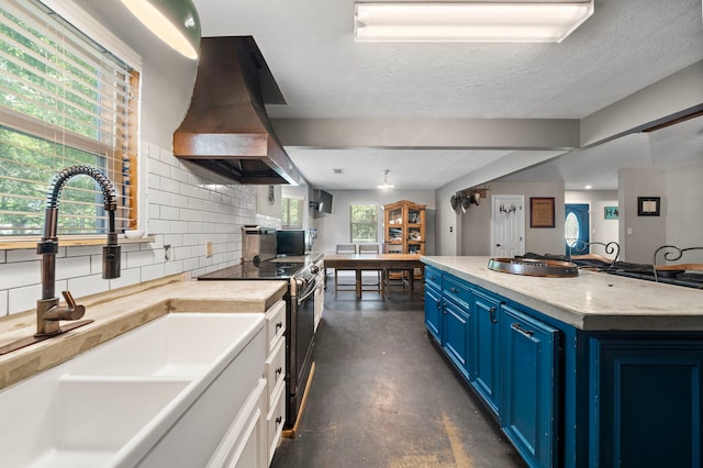 424 Hankamer Loop, Hankamer, TX 77560 - kitchen with blue cabinetry, a sink, island range hood, finished concrete flooring, and black electric range oven