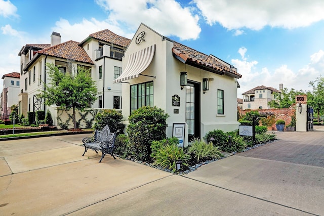 7506 Little Caprese Ln, Houston, TX 77055 - mediterranean / spanish house with a tiled roof, stucco siding, a chimney, and a residential view