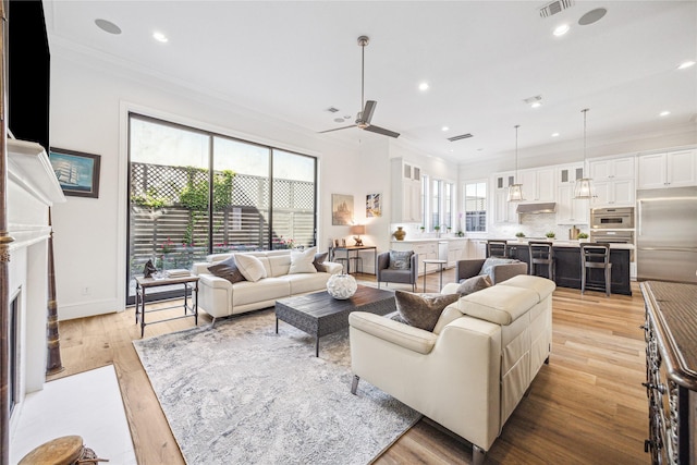 7506 Little Caprese Ln, Houston, TX 77055 - living room with ornamental molding, ceiling fan, light wood-style flooring, recessed lighting, and a fireplace