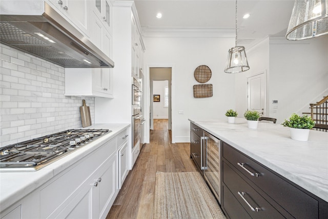 7506 Little Caprese Ln, Houston, TX 77055 - kitchen with extractor fan, appliances with stainless steel finishes, beverage cooler, crown molding, and white cabinetry