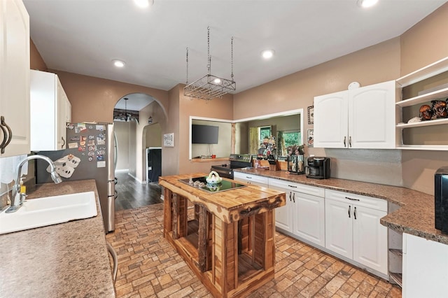560 Donahoe Rd, Coldspring, TX 77331 - kitchen featuring a sink, arched walkways, appliances with stainless steel finishes, white cabinets, and recessed lighting