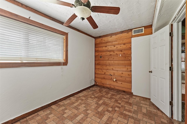 560 Donahoe Rd, Coldspring, TX 77331 - unfurnished bedroom with wood walls, brick patterned floors, and ceiling fan