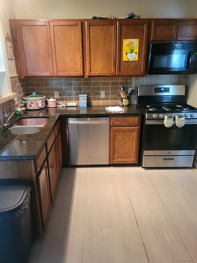 118 Whiting St, Galveston, TX 77550 - kitchen with appliances with stainless steel finishes, decorative backsplash, dark stone countertops, and brown cabinets