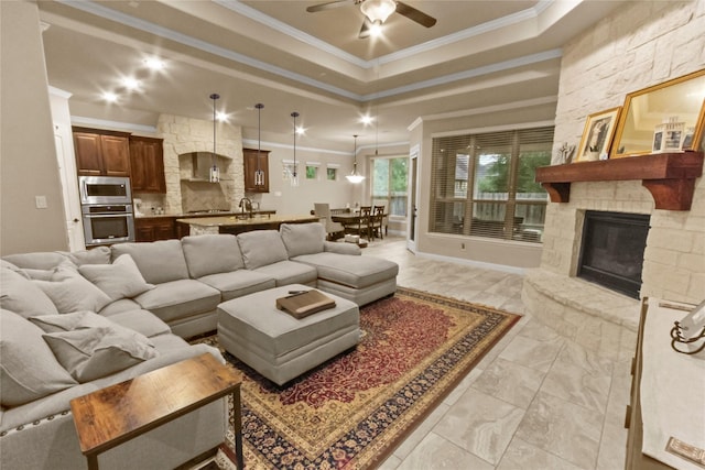 31428 Longwood Park Ln, Spring, TX 77386 - living area featuring ornamental molding, a stone fireplace, a raised ceiling, a ceiling fan, and light marble finish flooring