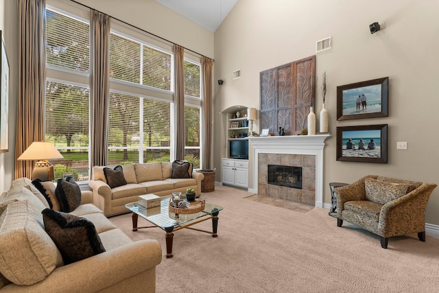 3 Forest Steppes Ct, The Woodlands, TX 77382 - living room featuring carpet, a towering ceiling, a tiled fireplace, and plenty of natural light
